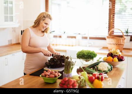 Femme enceinte préparer un repas dans la cuisine à partir d'ingrédients frais Banque D'Images