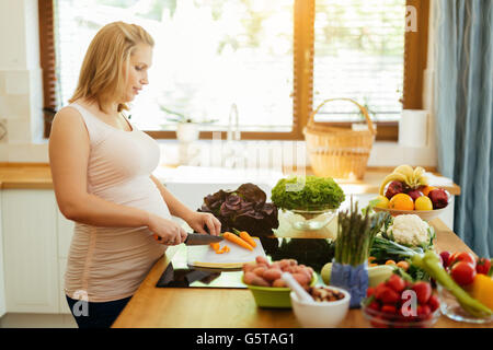 Femme enceinte manger sain la préparation de repas à partir de produits frais Banque D'Images