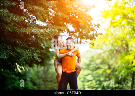 Man carrying woman piggyback après le jogging est fait
