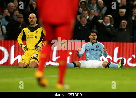 Sergio Aguero de Manchester City (à droite) célèbre après avoir marqué celui de son équipe Deuxième but prochain gardien de but de Liverpool Pepe Reina qui semble abattu Banque D'Images
