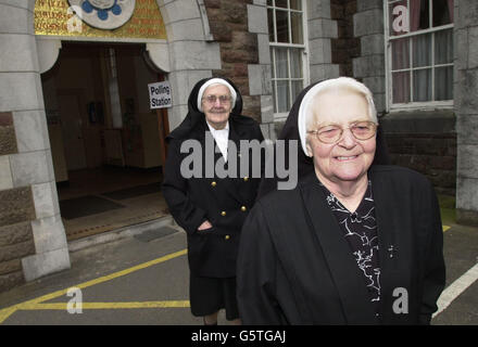 Les nonnes quittant un bureau de vote à l'église catholique romaine de Saint-Jean à Tralee, Co. Kerry, après avoir voté aux élections générales de la République d'Irlande. Banque D'Images