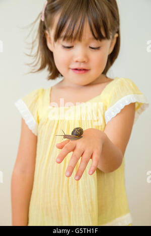 Bébé fille tenant un escargot, La Jolla, Californie Banque D'Images