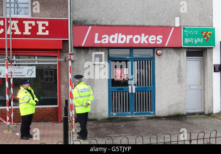 La police sur les lieux d'une tentative de vol à main armée à la succursale de Ladbrokes sur Crownhill Road à Plymouth, Devon, où un voleur armé masqué s'est effondré et est mort après avoir été désarmé et épinglé par des clients dans les livres. Banque D'Images