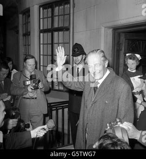 Harold Macmillan, l'ancien premier ministre, fait des vagues alors qu'il quitte la voiture pour arriver à l'hôpital King Edward VII de Marylebone, Londres, après avoir fait un trajet avec sa femme, Lady Dorothy Macmillan. À son retour à l'hôpital, M. Macmillan a été emmené à l'intérieur en fauteuil roulant. Il se remet d'une opération de la prostate. Banque D'Images