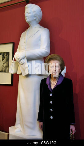 L'ancienne première ministre britannique Margaret Thatcher se trouve à côté de sa statue en marbre plus grande que nature, qui a été dévoilée au Guild Hall de Londres. La baronne Thatcher a cassé les ordres des médecins de ne pas faire de discours publics quand elle est arrivée à la salle de guilde. *03/07/02: Un homme est entré dans la galerie et a frappé la statue avec un poteau de support de corde en métal et a frappé la tête. Un homme a été arrêté par les policiers de la ville de Londres et la statue a été retirée du champ de vision public. Banque D'Images