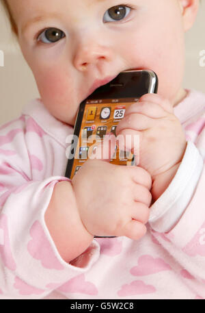 STOCKER bébé. Un bébé tenant un iPhone 3GS d'Apple. Banque D'Images