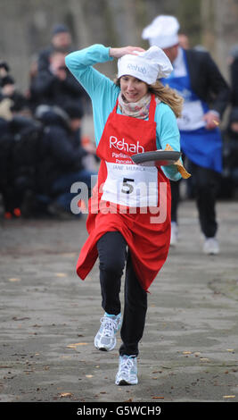 Les députés, les lords et les membres de la presse participent à la course annuelle de Rehab Pancake de cette année à Shrove mardi devant les chambres du Parlement à Londres aujourd'hui, y compris Jane Merrick de l'indépendant dimanche. Banque D'Images