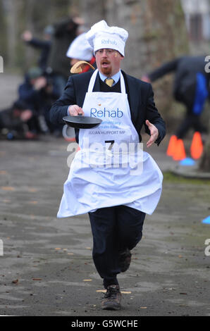 Les députés, les lords et les membres de la presse, dont le député Julian Huppert, participent aujourd'hui à la course annuelle de Rehab Pancake à Shrove mardi devant les chambres du Parlement à Londres. Banque D'Images