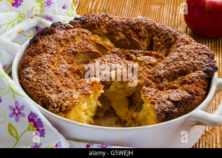 Tarte aux pommes dans un plat de cuisson blanc sur le fond de bois. Banque D'Images