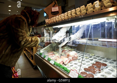 Un client reçoit des conseils sur diverses viandes emballées à vide au comptoir de la ferme biologique Sheeproud de Bristol. Banque D'Images