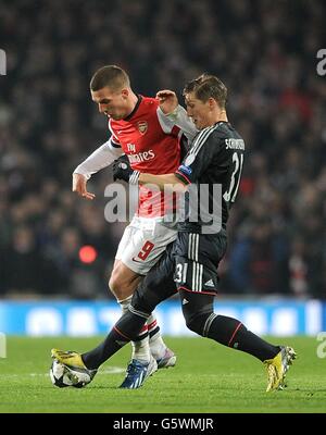 Lukas Podolski d'Arsenal et Bayern Munich Bastian Schweinsteiger (à droite) bataille pour le ballon Banque D'Images