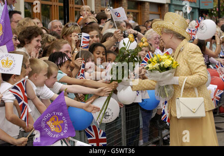 La reine Elizabeth II accepte les fleurs des enfants du centre-ville d'Uxbridge lors de sa visite du Jubilé d'or à Middlesex. Banque D'Images