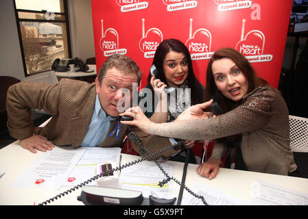 (De gauche à droite) Jon Culshaw, Dani Harmer et Debra Stephenson dans le centre d'appels pendant le coeur FM's Har a Heart Appeal 2013, à Global radio à Leicester Square, centre de Londres. Banque D'Images