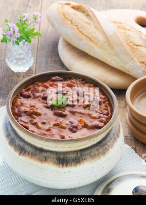 Vue de dessus du chili con cane ,repas selective focus tourné en une table en bois dans un endroit avec du pain et les plaques de réglage Banque D'Images