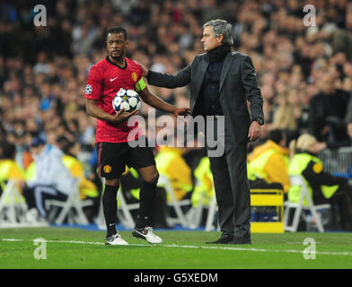 Patrice Evra de Manchester United (à gauche) et Jose Mourinho, responsable du Real Madrid, lors du match de la Ligue des champions de l'UEFA de 16 à Santiago Bernabeu, Madrid, Espagne. Banque D'Images