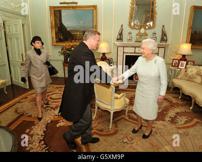 La reine Elizabeth II tremble la main avec le haut-commissaire de l'Australie, M. Mike Rann, puis son épouse Sasha, après son arrivée pour un public privé avec sa Majesté, au Palais de Buckingham, dans le centre de Londres. Banque D'Images