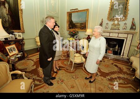 La reine Elizabeth II tremble la main avec le haut-commissaire de l'Australie, M. Mike Rann, puis son épouse Sasha, après son arrivée pour un public privé avec sa Majesté, au Palais de Buckingham, dans le centre de Londres. Banque D'Images