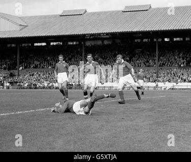 Norman Uprichard, gardien de Portsmouth, fait une économie au niveau du sol lors du match de la première division contre Chelsea au pont Stamford à Londres.Les joueurs en arrière-plan, de gauche à droite, sont Phil Gunter, Portsmouth, Seamus O'Connell,Chelsea Inside-left, un joueur non identifié de Portsmouth et Frank Blunstone, Chelsea outside-left. Banque D'Images