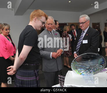 Le Prince de Galles (au centre), connu sous le nom de duc de Rothesay en Écosse, rencontre le propriétaire d'Aye Glass Angus Corbett (à gauche), lors d'une visite au Prince's Trust Wolfson Centre, à Glasgow. Banque D'Images