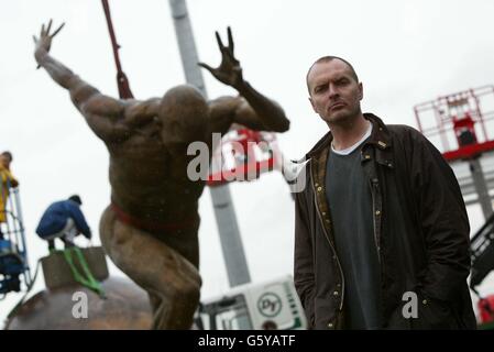 Colin Spofforth se dresse devant sa sculpture « The Runner » en position par le stade de la ville de Manchester avant le début des Jeux du Commonwealth fin juillet 2002. La statue doit être dévoilée au cours d'une cérémonie plus tard aujourd'hui. Banque D'Images