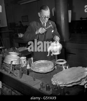 Un artisan appliquant la marque de fabrique pour l'année de couronnement au Assay Office of Worshipful Company à Goldsmitess' Hall. La marque spéciale, approuvée par la Reine, est appliquée à l'argent et à l'or fabriqués en Grande-Bretagne pour la vente en 1953. Banque D'Images