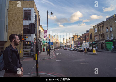 Un jeune homme barbu traversant le Kingsland Road, Broadgate et le fragment dans l'arrière-plan, Hoxton, Londres, Angleterre Banque D'Images