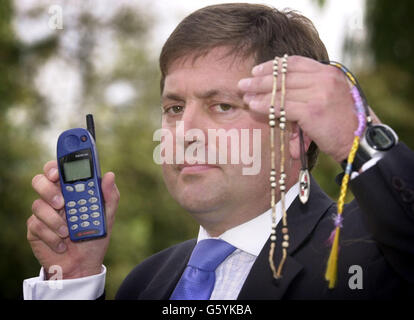 L'inspecteur en chef du détective Andy Hebb de la police de Cambridgshire tient, un collier et un téléphone qui sont des répliques de ceux qui appartiennent à des écolières disparues Jessica Chapman et Holly Wells. * quelque 300 policiers ont rejoint la chasse pour les deux jeunes qui ont disparu dimanche dernier et les détectives sont impatients de retrouver le conducteur d'une voiture verte conduite erratiquement sur la route entre Soham et Newmarket après qu'un chauffeur de taxi a dit qu'il a vu le conducteur apparemment lutte avec deux enfants. Banque D'Images