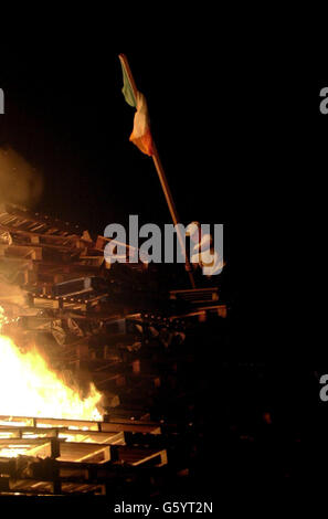 Loyalist jette un drapeau tricolore sur un feu de Banque D'Images