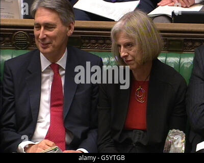 Le secrétaire à la Défense, Philip Hammond (à gauche), et la secrétaire à l'intérieur, Theresa May (à droite), écoutent le chef du parti travailliste, Ed Miliband, qui s'exprime lors des questions du premier ministre à la Chambre des communes, à Londres. Banque D'Images