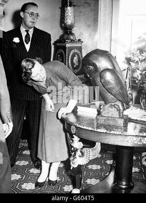 La princesse Beatrix examine une sculpture de chouette, qui était un cadeau du 18e anniversaire de la ville d'Amsterdam, lors d'une visite au Palais Soestdijk aux pays-Bas. En arrière-plan se trouve son père, le prince Bernhard des pays-Bas. La princesse a célébré son anniversaire hier. Banque D'Images