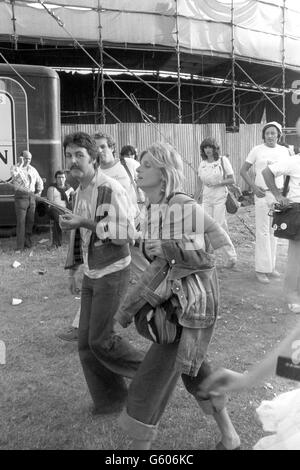 L'ancienne star des Beatles, Paul McCartney, et sa femme, Linda, tous deux membres du groupe de pop Wings, au Knebworth Park lorsqu'ils ont assisté au concert d'une journée sur le site de Hertfordshire.Près d'un quart de million de fans en sont venus à regarder la performance, qui comprenait les Rolling Stones. Banque D'Images