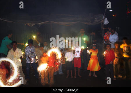 Les enfants pauvres bénéficiant des pétards et de cierges à l'occasion de Diwali en Inde Banque D'Images