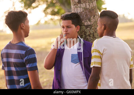 Les enfants dans le parc de fumer la cigarette électronique. Concept de fumeurs et les questions sociales avec les jeunes adolescents Banque D'Images