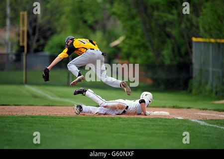 Premier but sautant par-dessus une base de plongée runner pour attraper un pick-off errant pas de la cruche que le coureur est arrivé en toute sécurité. USA. Banque D'Images