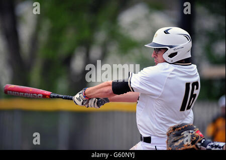 Frappeur gaucher de la prise de contact et de frapper la balle à l'autre pendant un match de baseball de l'école secondaire. USA. Banque D'Images