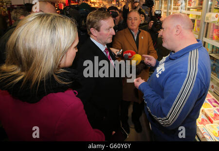 Taoiseach Enda Kenny parle avec un Garda hors service (nom non donné) dans un supermarché à Ratoath comme il rejoint le candidat de Fine Gael Helen McEntee (à gauche) sur la piste de campagne à l'élection partielle Meath East. Banque D'Images