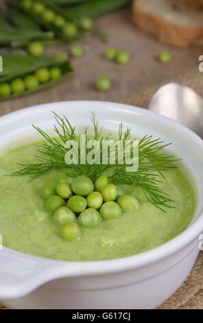 Une assiette de soupe purée de pois verts à l'aneth sur une table Banque D'Images