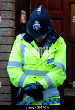 Un policier se tient devant la porte d'entrée d'une maison à Chaucer Grove, Atherton, où le corps d'une fille de 14 ans, considérée comme Jade Anderson, a été trouvé maudit par des chiens « agressifs et hors de contrôle ». Banque D'Images