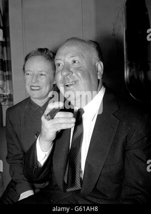 Alfred Hitchcock, réalisateur et producteur, adopte la posture churchillienne lorsqu'il arrive avec sa femme à Southampton à bord de la Cunarder 'Queen Elizabeth' de New York. Banque D'Images