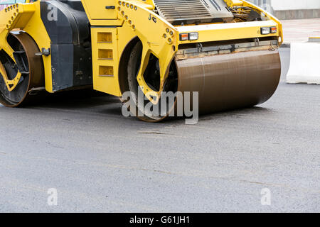 Compacteur rouleau jaune lourd l'asphaltage de la rue road Banque D'Images