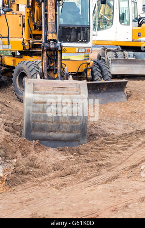 Excavatrice jaune sur la construction de nouvelles routes plan du Banque D'Images