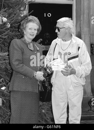 Margaret Thatcher avec Jimmy Saville à l'extérieur du n° 10 Downing Street où Jimmy a remis à Mme Thatcher deux chèques, chacun d'une valeur de 10,000, de ses courses sponsorisées pour la Société de sclérose en plaques et de l'équitation pour les handicapés. Banque D'Images