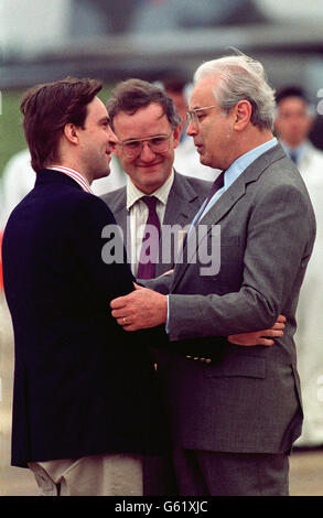 L'ancien otage du Moyen-Orient John McCarthy et le Secrétaire général des Nations Unies Perez de Cuellar se embrassent une fois que le secrétaire général est arrivé à RAF Lyneham. Au centre de la photo se trouve le ministre des Affaires étrangères, Douglas Hogg. Banque D'Images