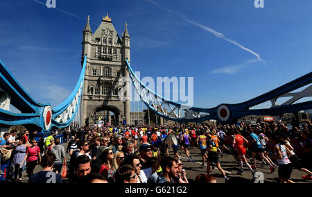 Les spectateurs regardent les coureurs traverser le Tower Bridge lors du marathon de Virgin London à Londres. Banque D'Images