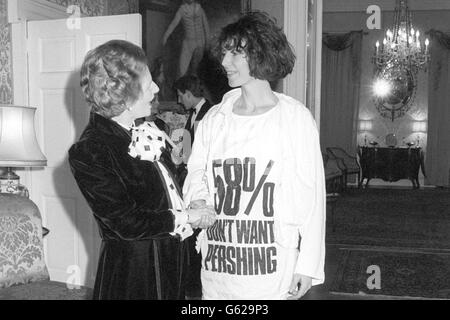 La première ministre Margaret Thatcher accueille la couturier Katharine Hamnet, vêtue d’un message de protestation portant un missile nucléaire, au 10 Downing Street, où elle a accueilli une réception pour les designers de la British Fashion week. Banque D'Images