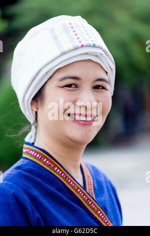 Thaïlande, Nord de la Thaïlande, région de Chiang Mai. A Tai lue (alias Thai lue / Tai le / Tai Lü / Dai) femme indigène en robe traditionnelle souriant à la caméra Banque D'Images