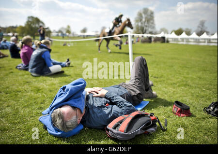 Un homme se détend au soleil par le cours de cross-country pendant le premier jour des épreuves de badminton à Badminton, Gloucestershire. Banque D'Images