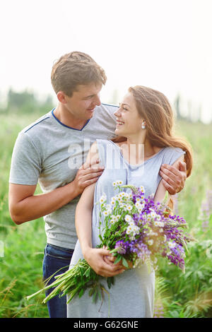 Couple heureux de jouer les uns avec les autres dans un champ bouquet de lupins Banque D'Images