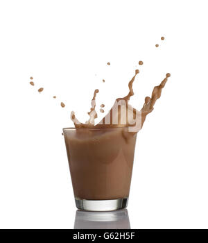 Lait au chocolat ou lait frappé de protéines circulant dans un verre, ce qui fait grand bruit, isolé sur fond blanc Banque D'Images