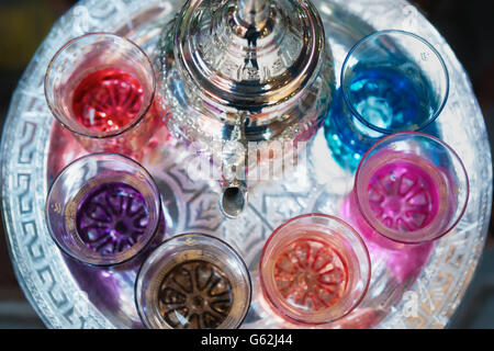 Verres à thé marocain coloré avec plateau pot dans un plateau/bouilloire. Banque D'Images